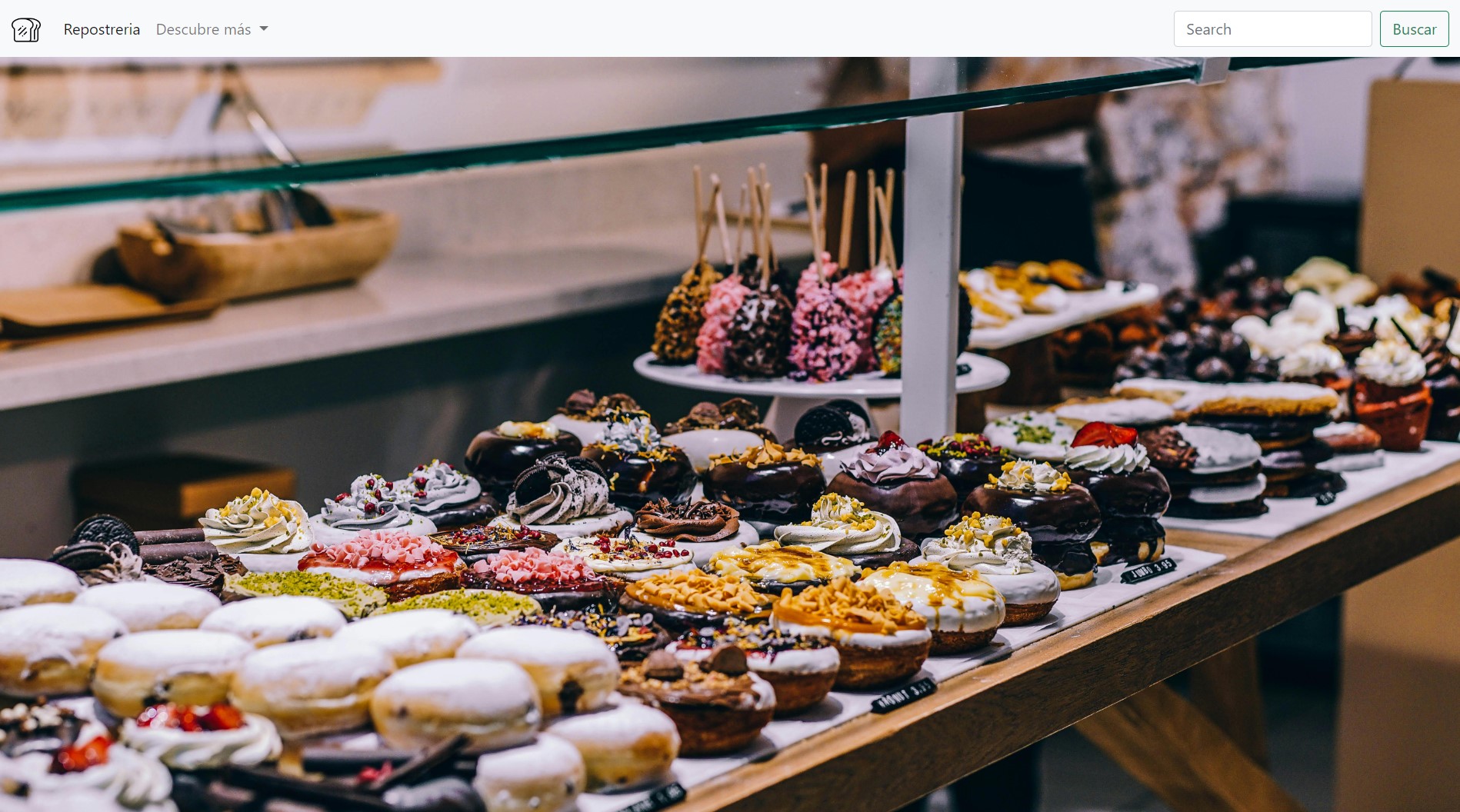 A display case in an artisanal bakery showing a variety of desserts, including donuts decorated with icing, cream, and various toppings